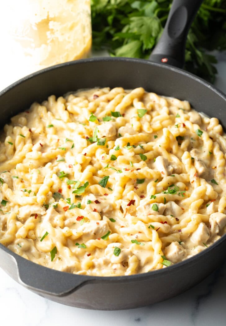 Black one pot with cooked pasta with garlic and parmesan.