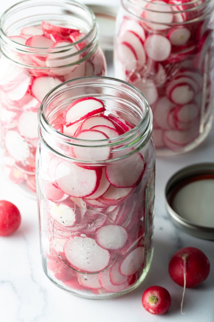 Large glass jars filled with radish slices.