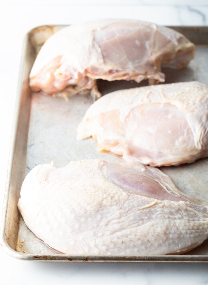 3 turkey breasts on a baking sheet.
