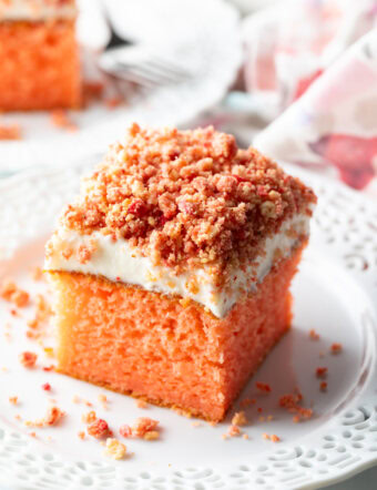 Square of strawberry crunch cake on a white plate.