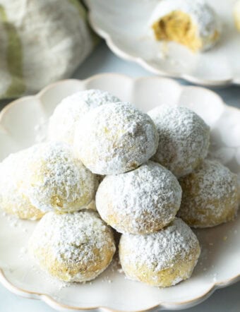 Pyramid stacks of almond and pistachio Italian wedding cookies dusted with powdered sugar.
