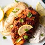 Harissa Chicken recipe on plates with hummus