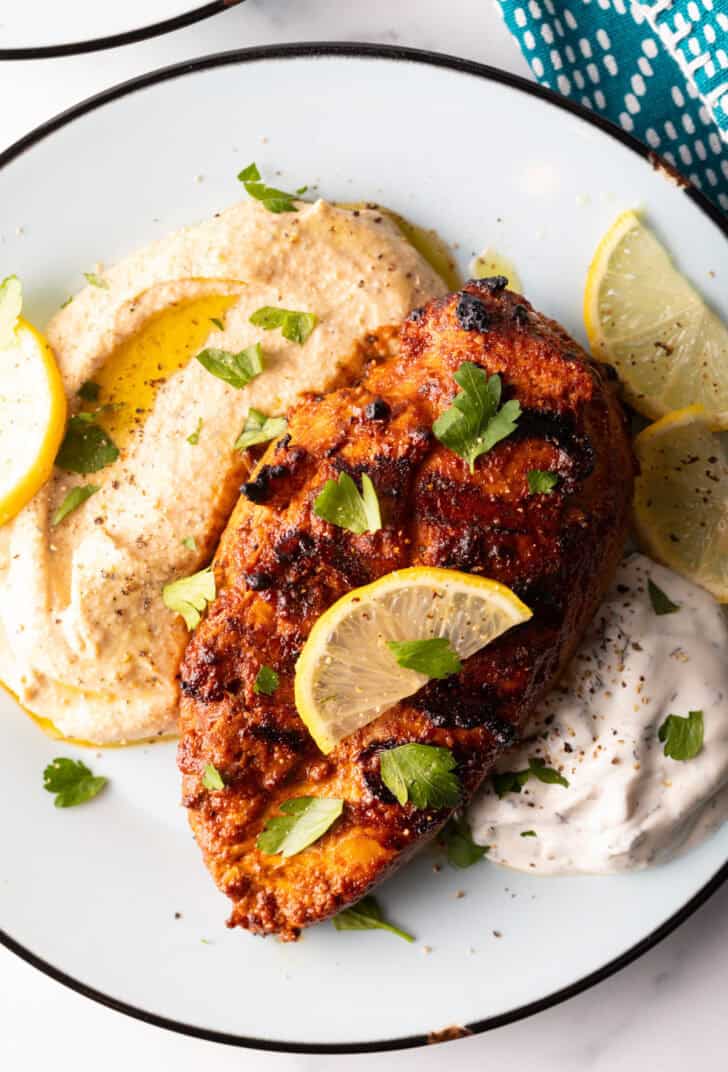 Harissa Chicken recipe on plates with hummus