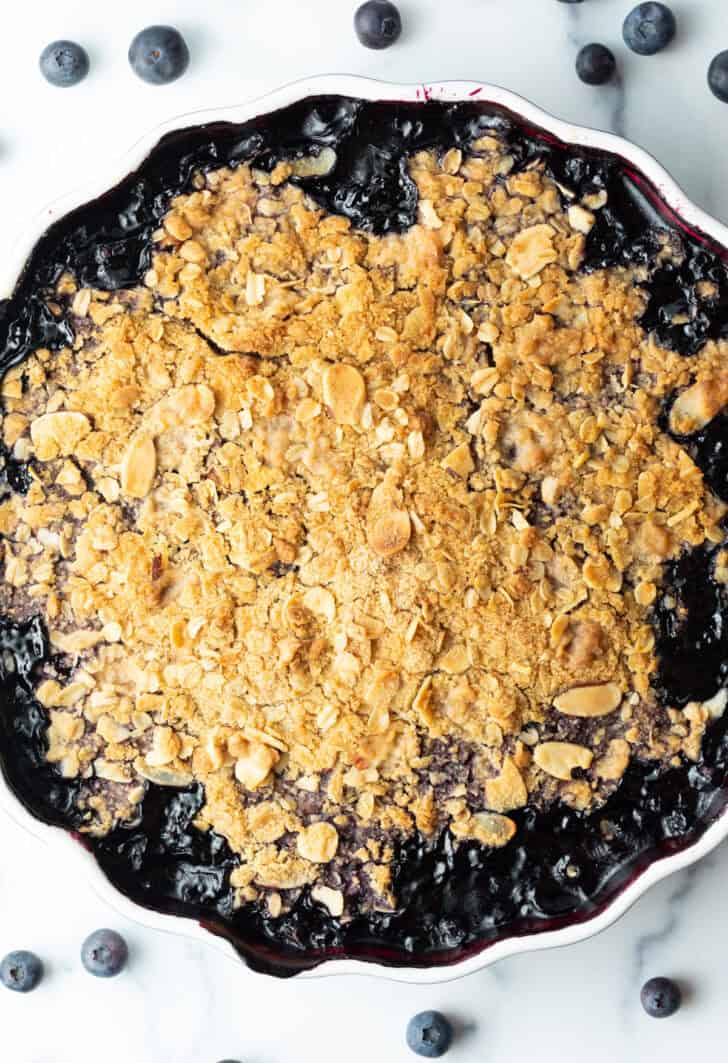 Scalloped round baking dish with blueberry crisp.