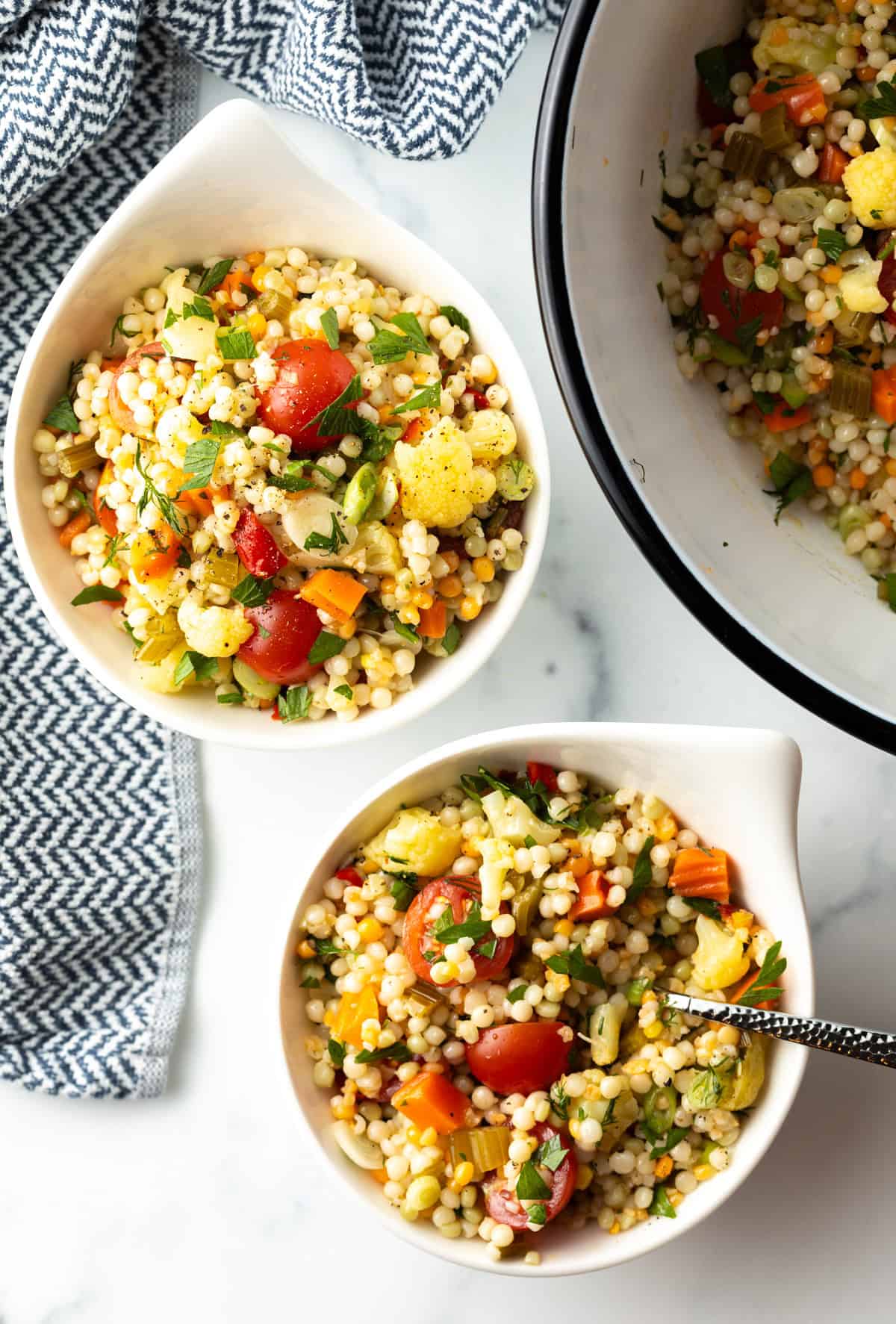 Top down view 2 bowls of cous cous salad.