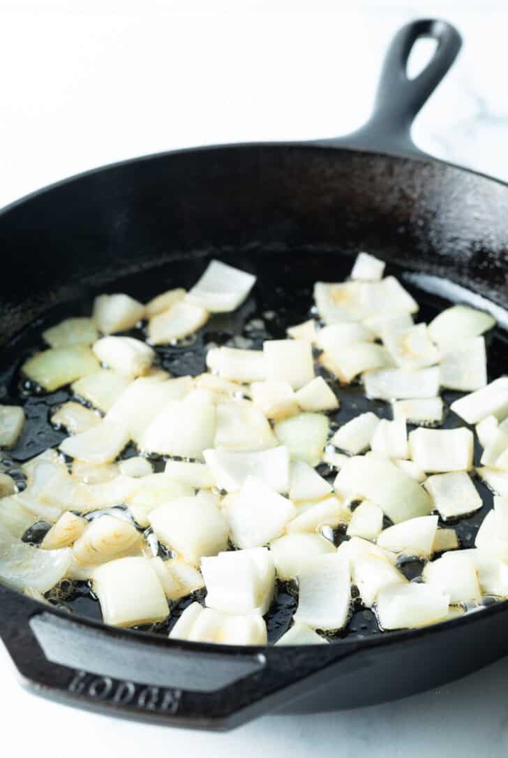 Chopped onion in a cast iron skillet.