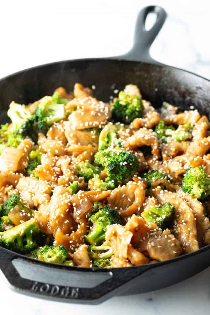 Chicken and broccoli in a large cast iron skillet.