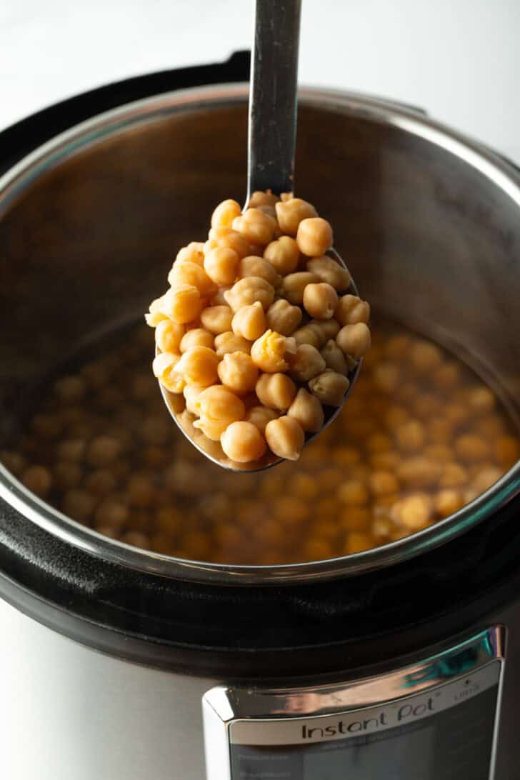 Spoonful of chickpeas held to camera.