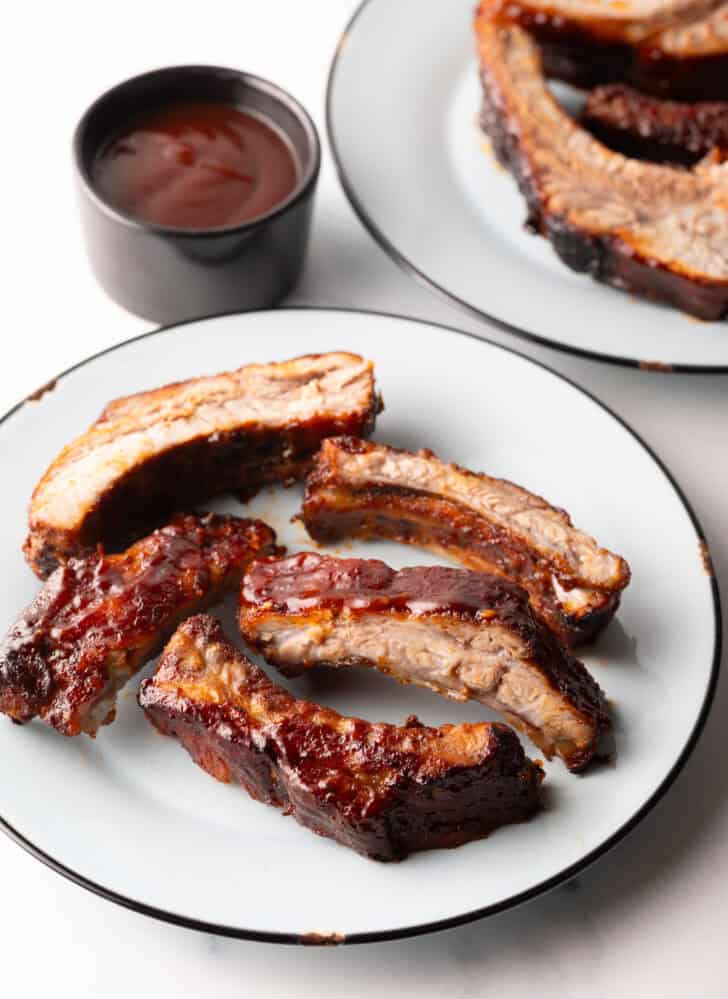 5 air fried baby back ribs on a white plate.