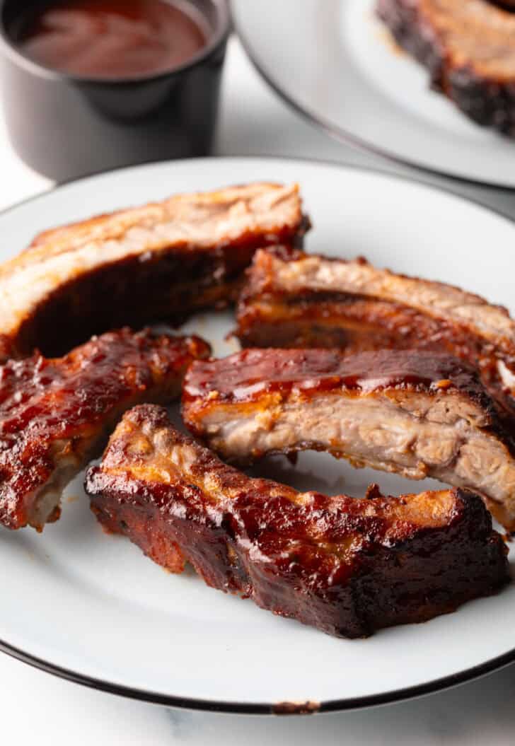 5 air fried baby back ribs on a white plate.