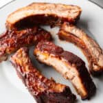 5 air fried baby back ribs on a white plate.