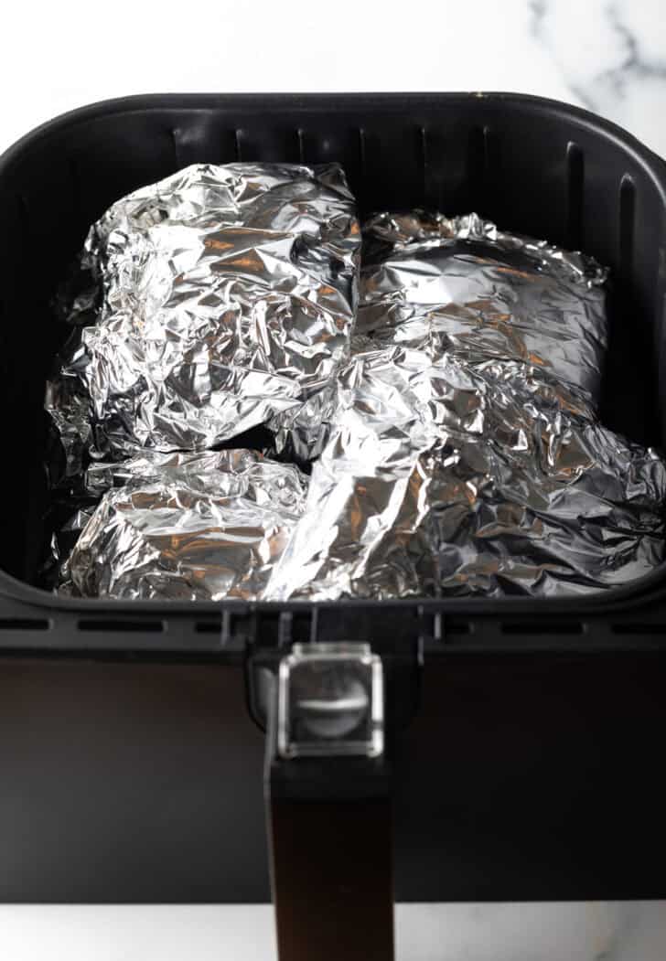 Ribs wrapped in foil cooking in the air fryer.