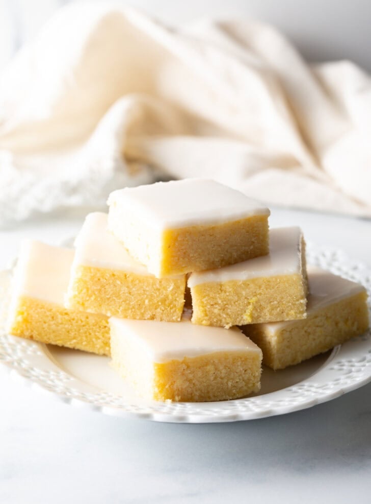 Plate of 6 lemon brownie squares stacked in a small pyramid.
