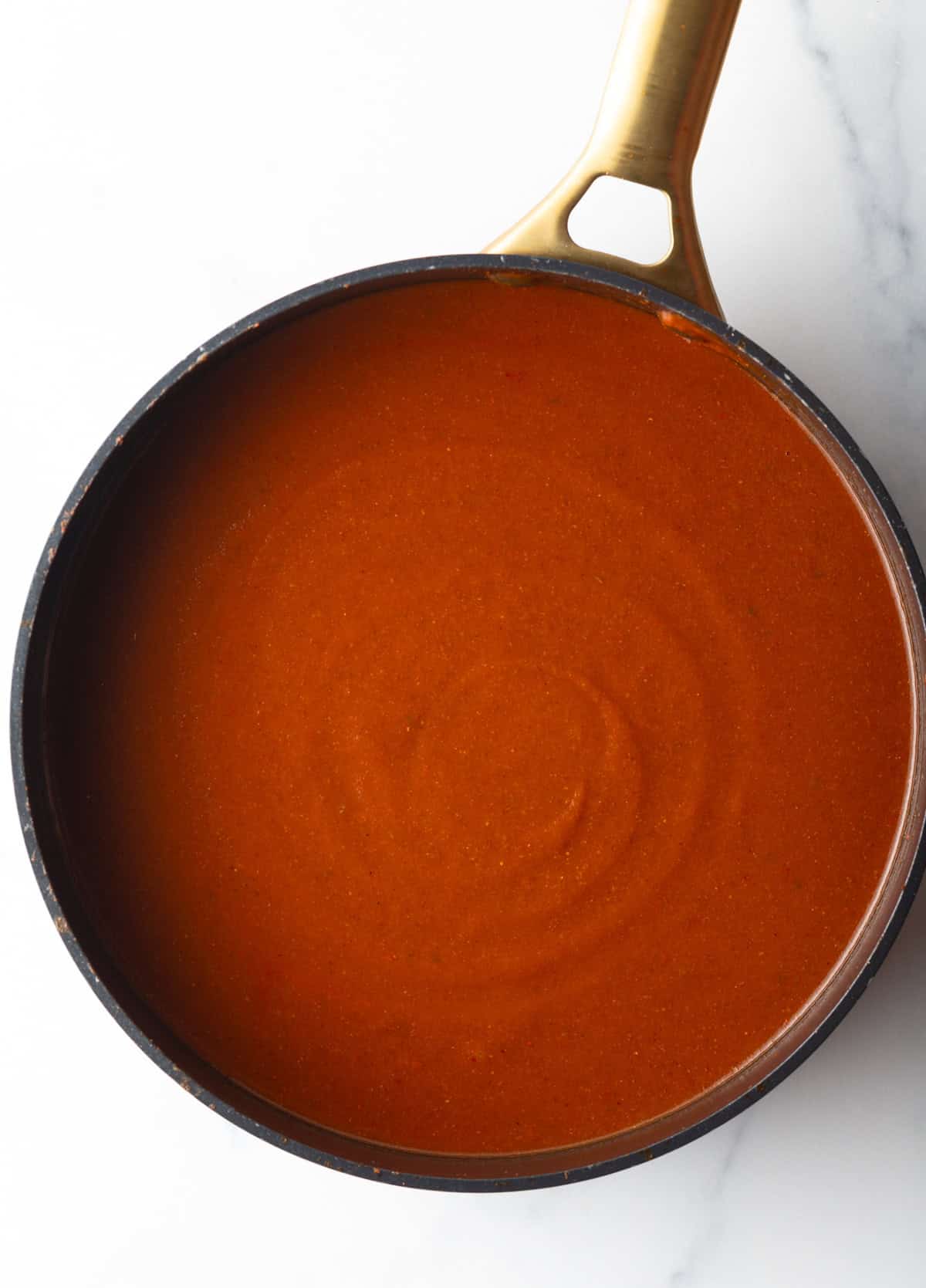 Top down view large deep skillet of red sauce.