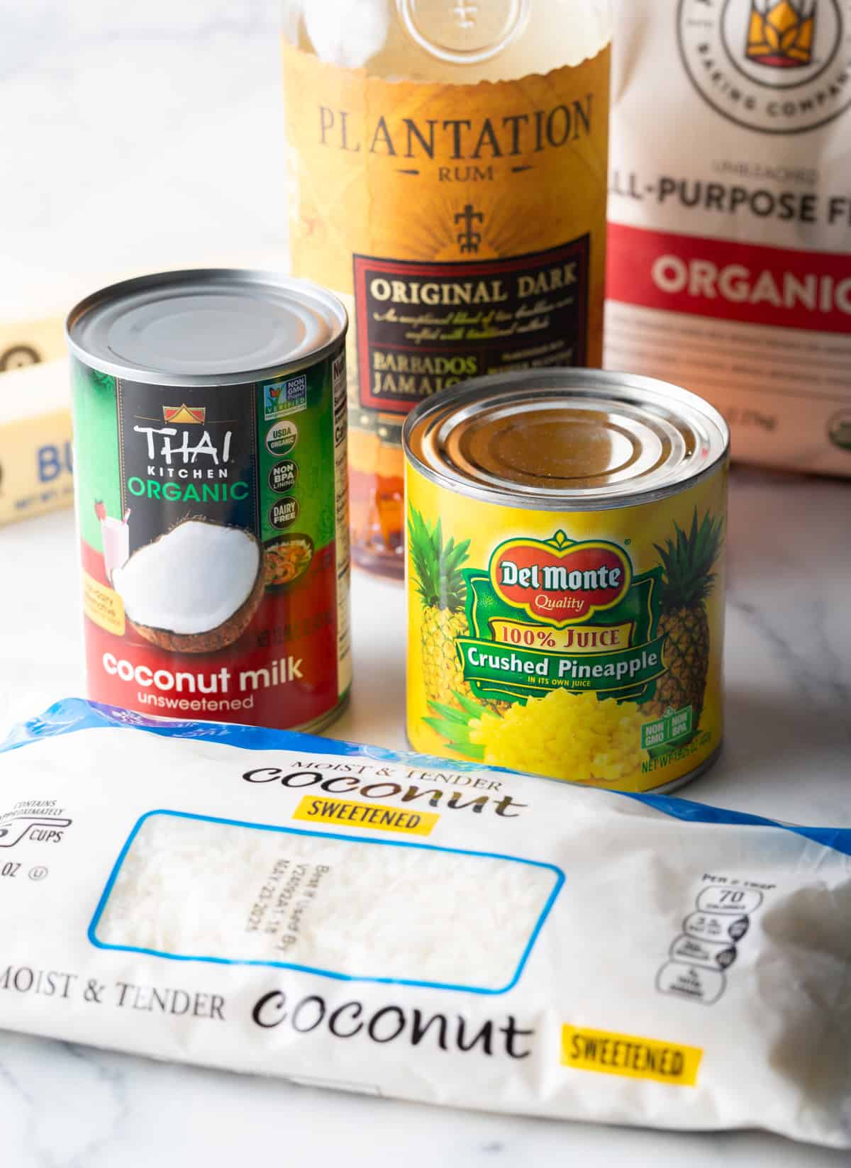 Can of coconut milk and crushed pineapple on a counter.