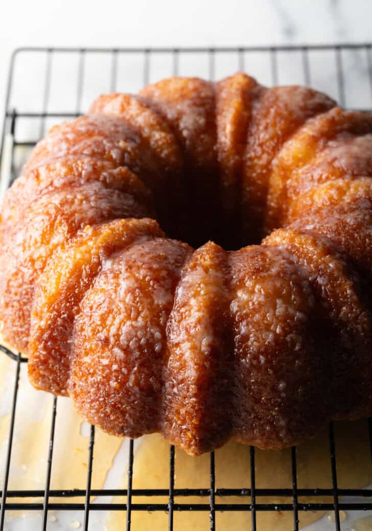 Baked bundt cake on a cooling rack, soaked with rum.