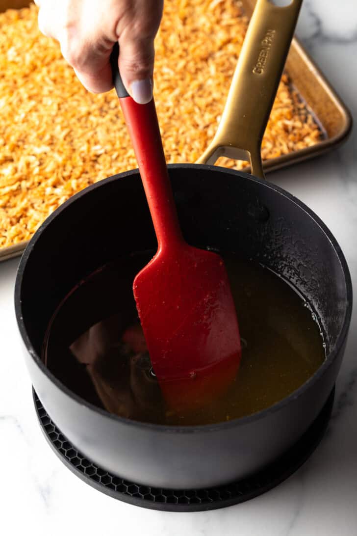 Red spatula stirring rum sauce.