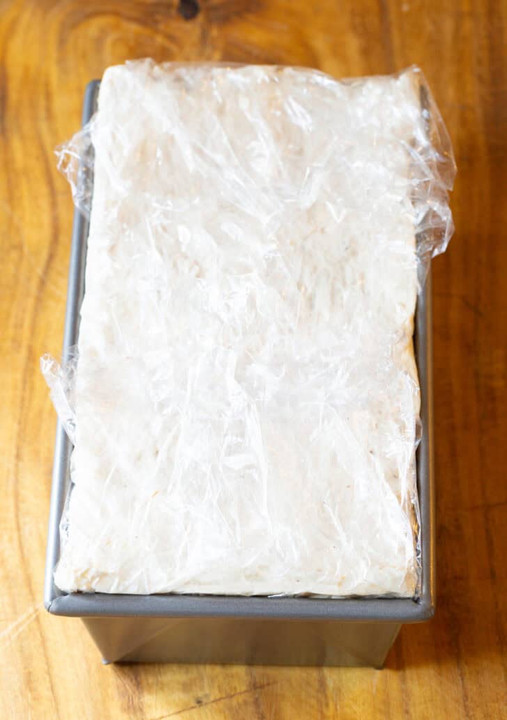 Frozen cake layered in a rectangle baking pan.