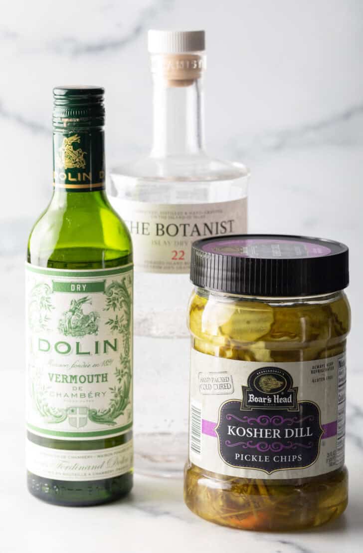Ingredients you need for a pickle martini: bottle of gin, a jar of dill pickle slices, and a bottle of vermouth.