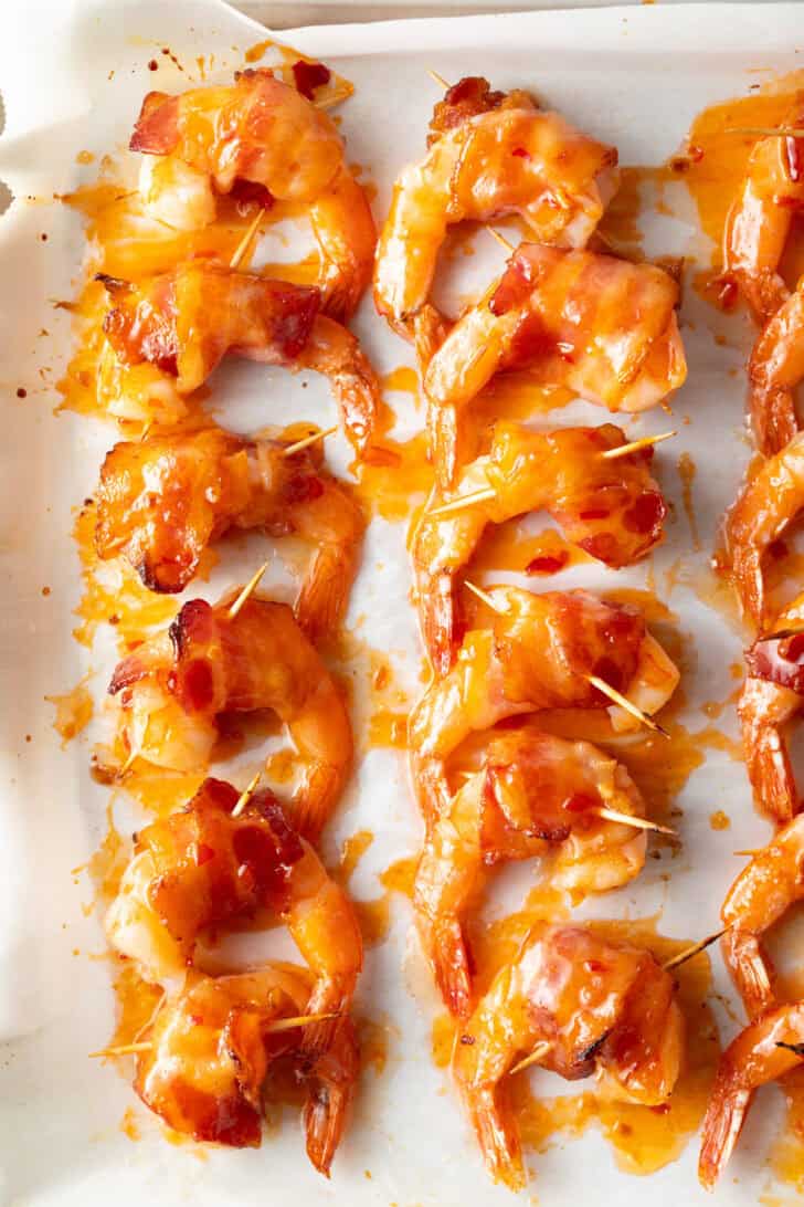 A dozen shrimp wrapped with bacon that's held in place with toothpicks.
