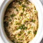 White crockpot with finished chicken and rice.