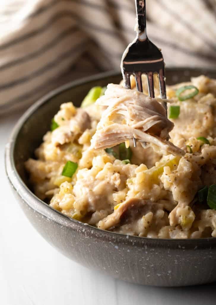 Chicken and rice in a black bowl with a fork.