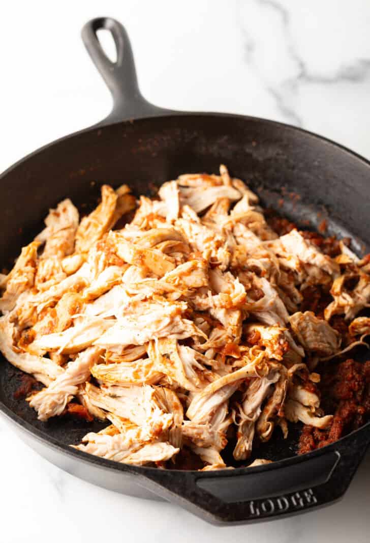 Shredded chicken in a cast iron skillet.