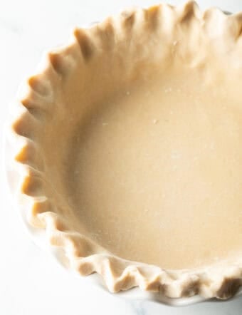 Unbaked pie dough with crimped edges in a pie plate.