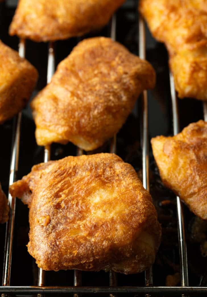 Several pieces of fried fish on a wire rack.