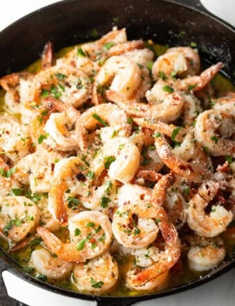 Shrimp in a skillet with herbs and garlic.