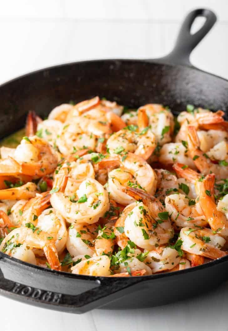 Shrimp in a skillet with herbs and garlic.