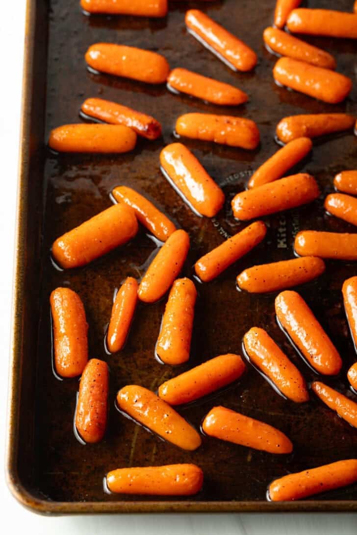 Roasted baby carrots on a baking sheet.