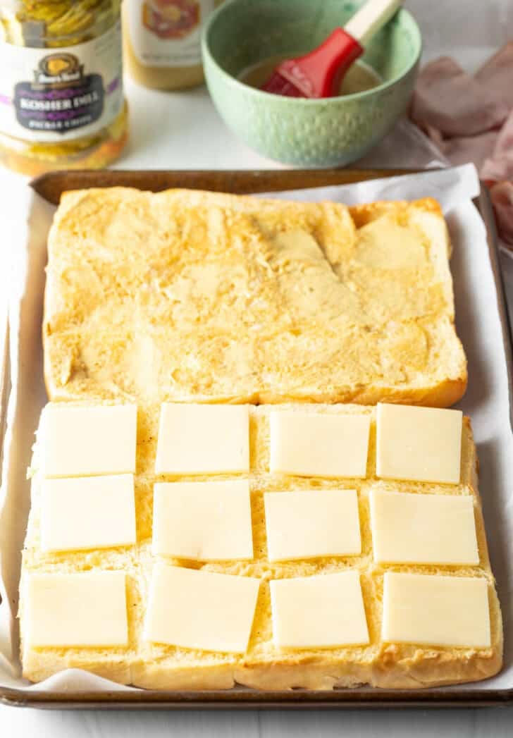 Making Hawaiian sliders with a bottom layer of cheese.