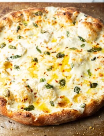 Baked whole white pizza on a baking sheet.
