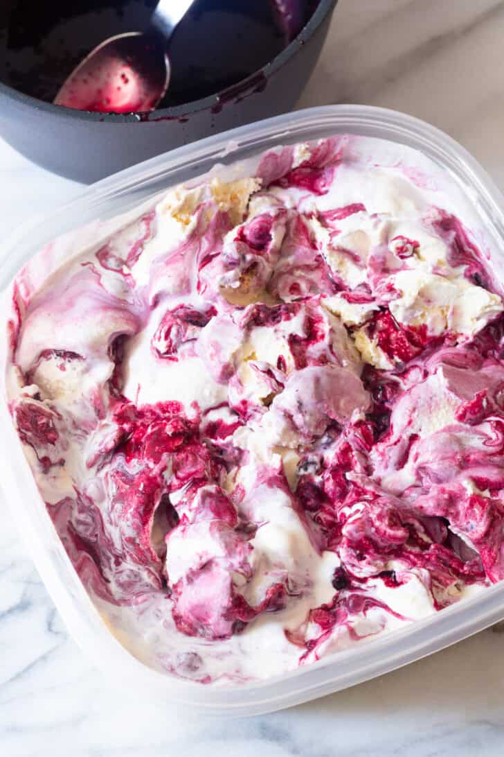 Plastic tub with blueberry pie ice cream.