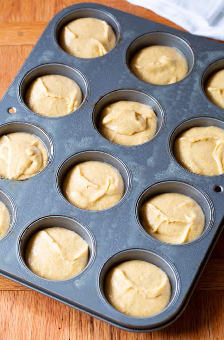 Corn muffin batter in a 12 cup baking tin.