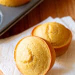 Two honey cornbread muffins on a white napkin.
