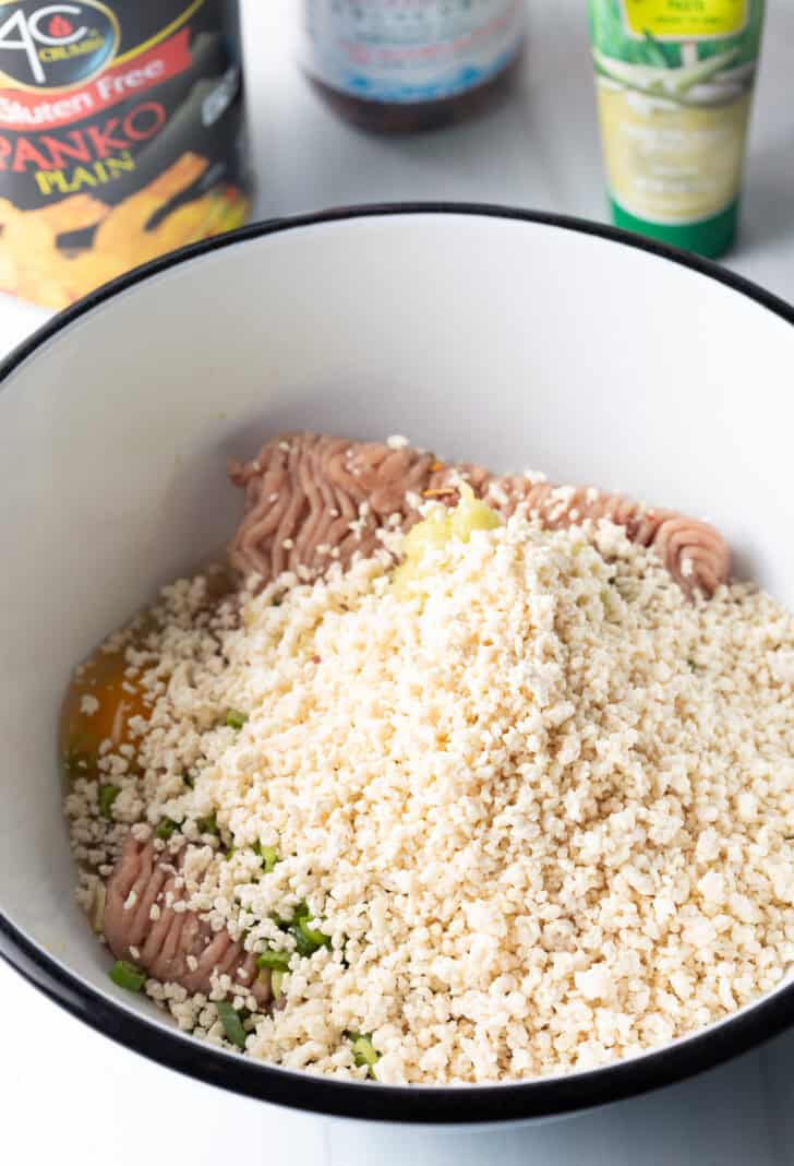 Ground turkey in a white bowl, covered in panko breadcrumbs.