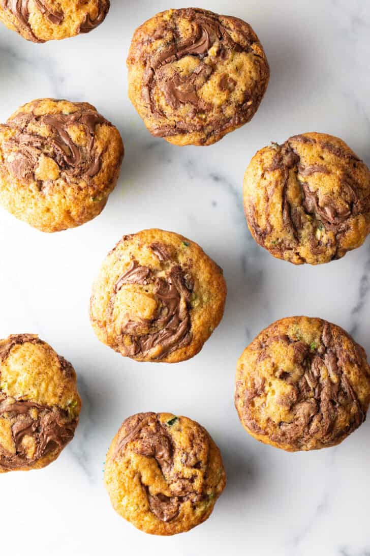 Top down a dozen zucchini muffins with chocolate.