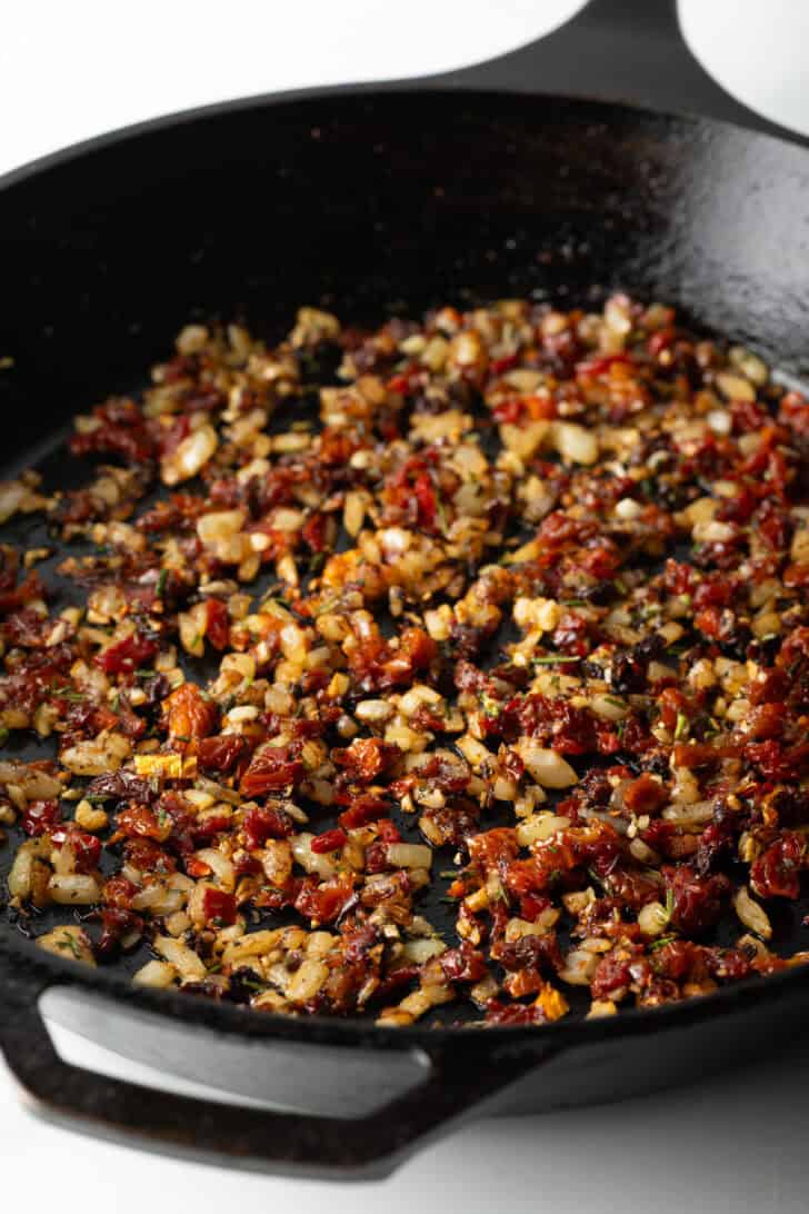 Cooking tomatoes, garlic and onion in a cast iron skillet.