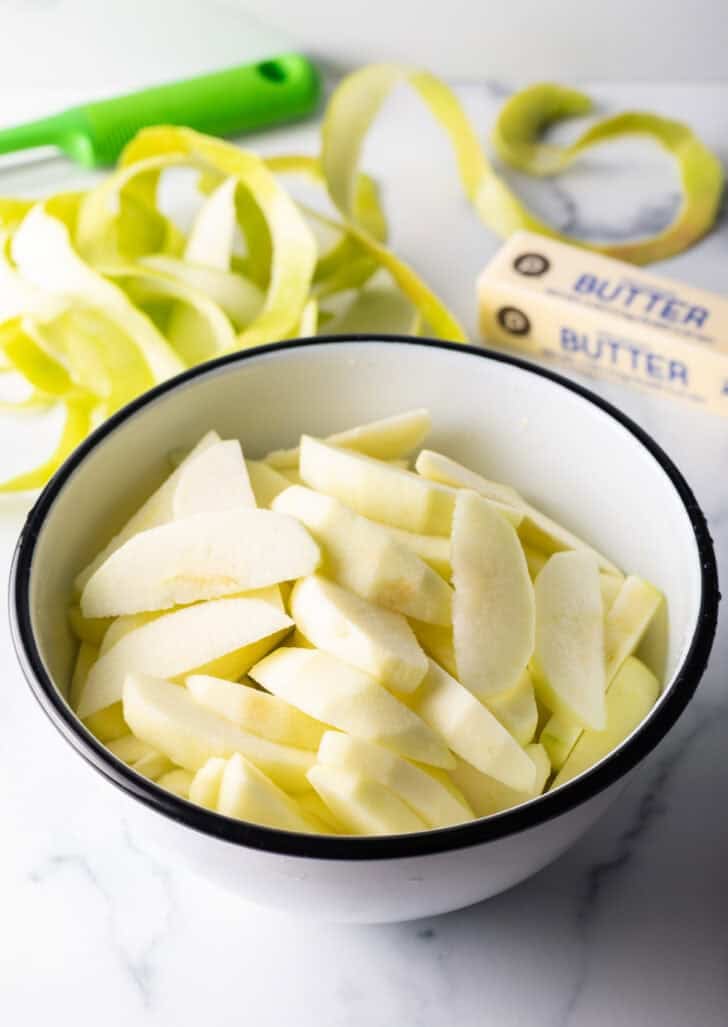 White bowlful of apple slices.