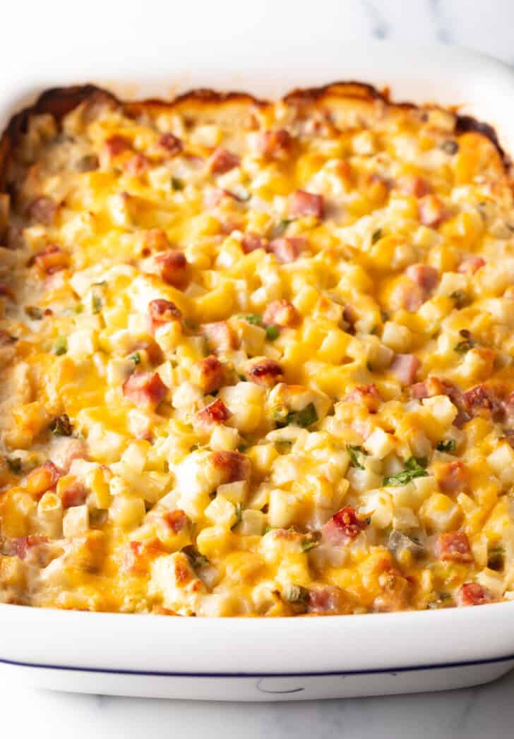 Baked ham and potato casserole in a white dish.