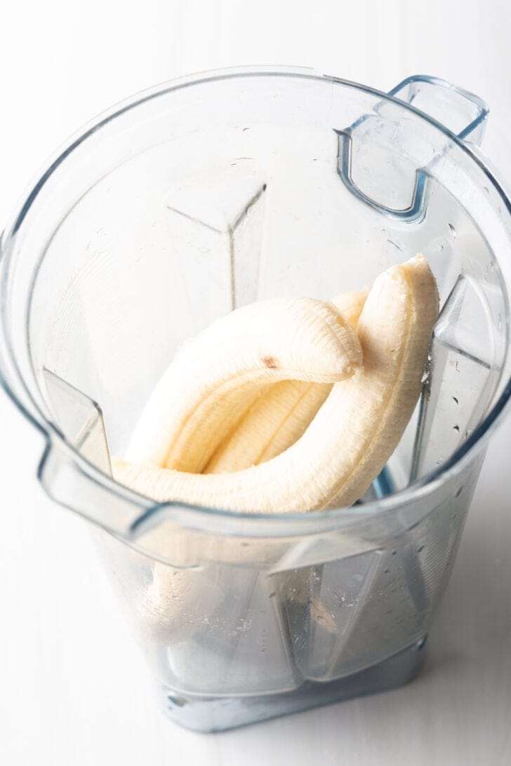 Three bananas in a blender jar.