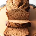 Loaf of healthy banana bread on a cutting board. Two front slices are layered.