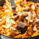 Large spoonful of chicken and pasta held to camera.