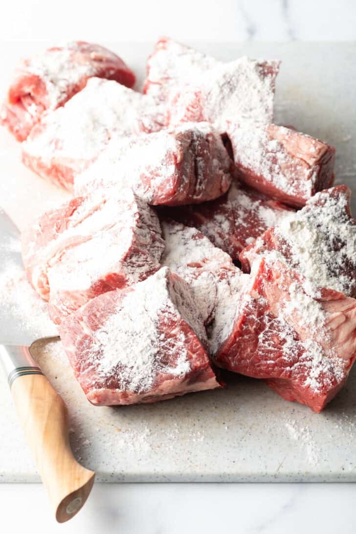 Large chunks of raw beef coated in flour.