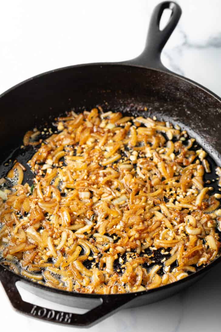Browning diced onions and garlic in a cast iron skillet.
