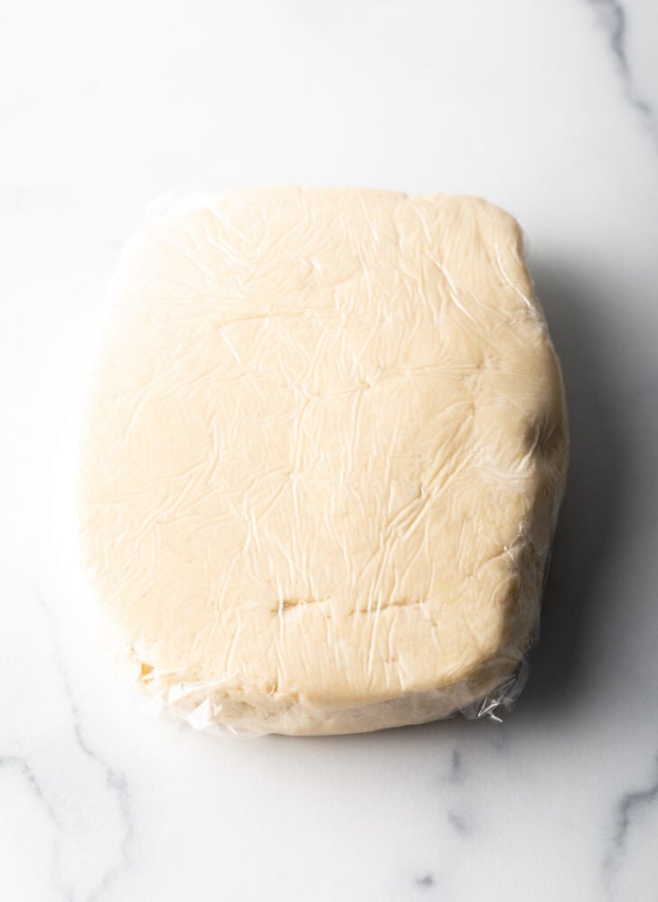 Rectangle of pie dough on a marble background.