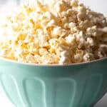 Blue bowl overflowing with butter popcorn.