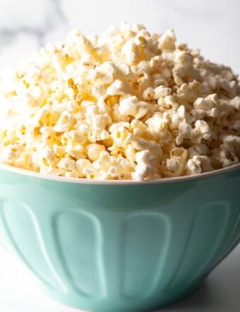Blue bowl overflowing with butter popcorn.